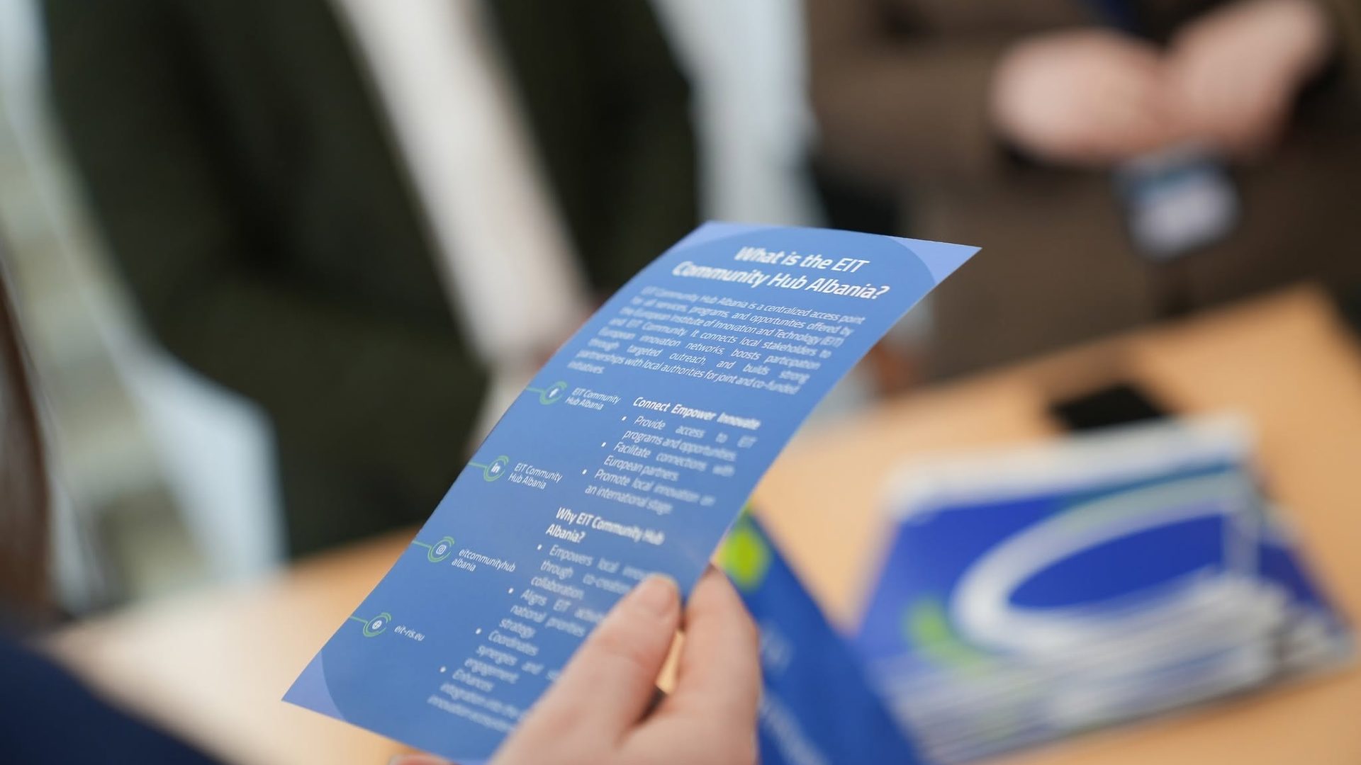 Visitor reading an EIT Community Hub Albania leaflet at MatchMaker 2026