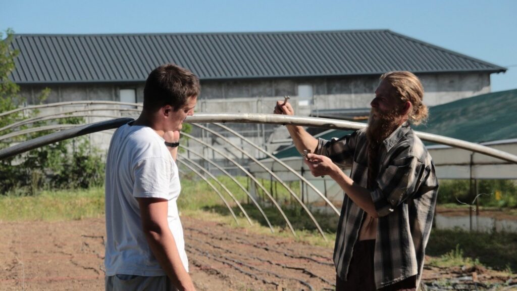 Two Plovi Farma team members working on the greenhouse structure on the farm in Montenegro